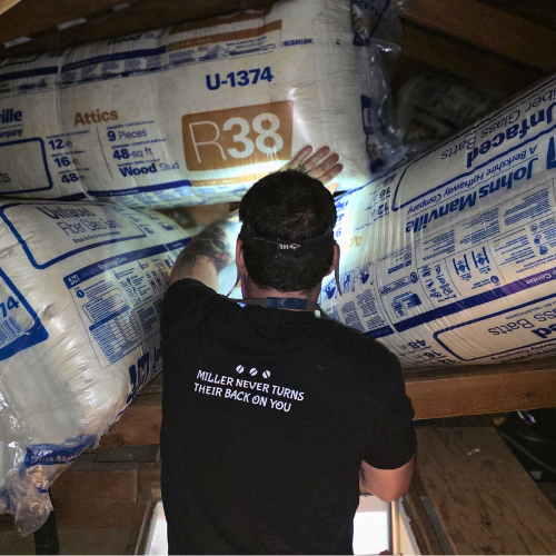 miller attics worker holding insulation
