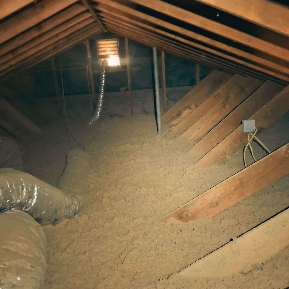 Insulation work inside a real San Anselmo attic — San Anselmo's 1920s–1940s Spanish-Mediterranean homes downtown and mid-century ranches up Sleepy Hollow and Butterfield often need full-depth cellulose after decades of inland-valley heat and cool-wet winters