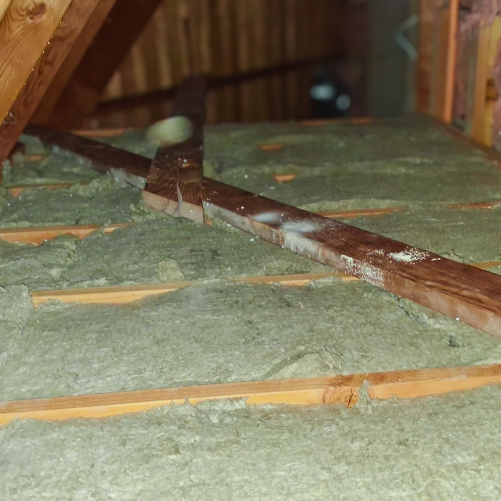 Insulation work inside a real Larkspur attic — 1920s–1940s craftsman bungalows in downtown Larkspur and Madrone Canyon hillside homes often need full-depth cellulose after decades of settling
